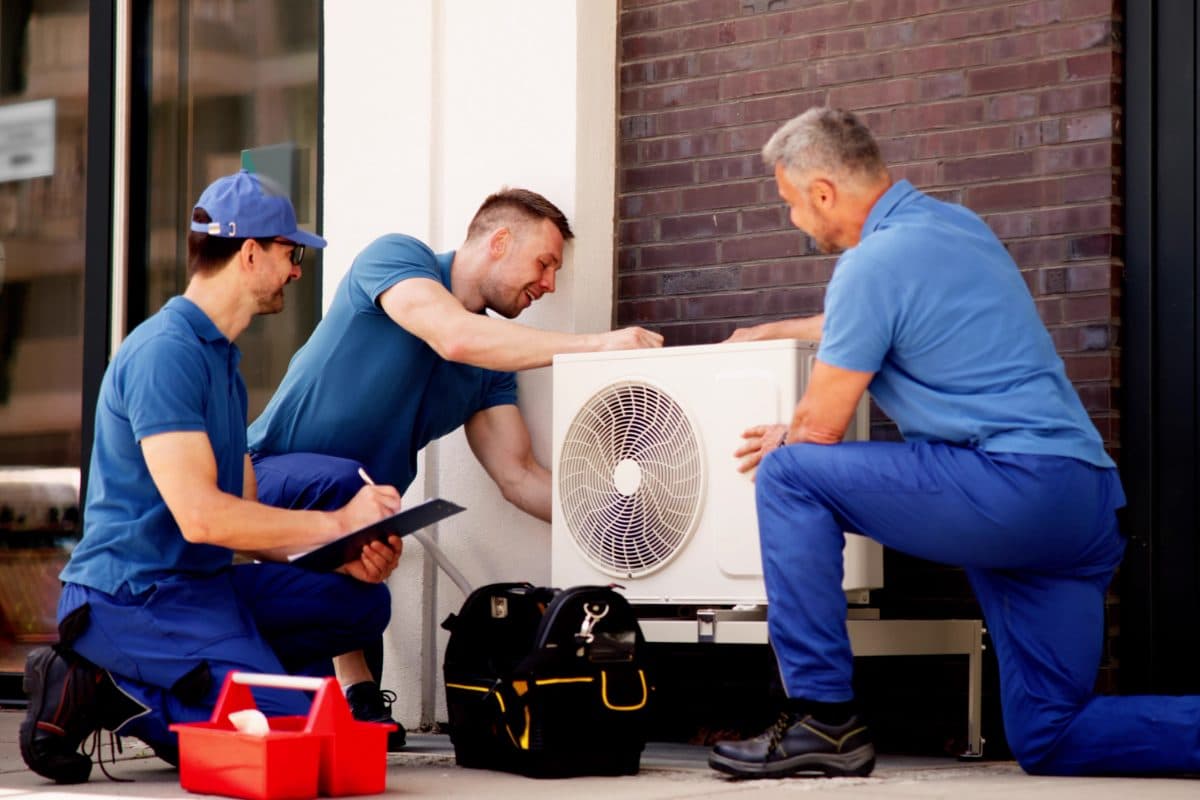 ARS technicians installing an outdoor HVAC condenser unit